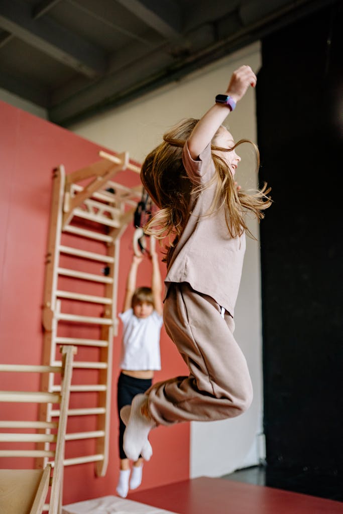 Kids having fun and keeping active by jumping in an indoor gym setting.